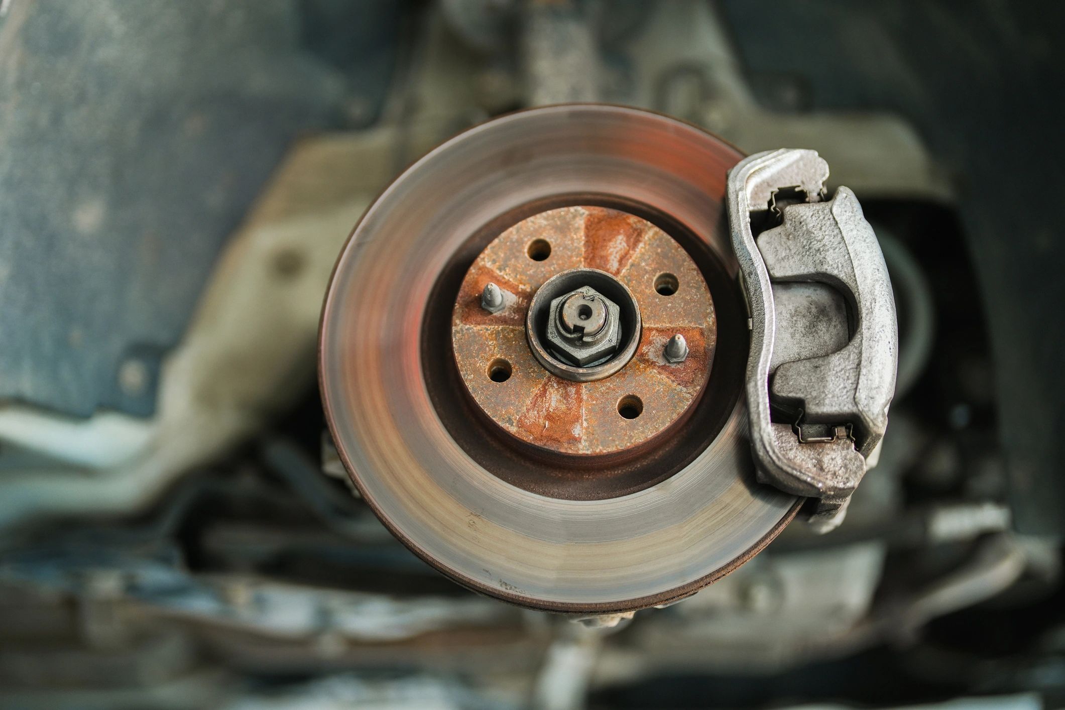 Mechanic maintaining front brake components on a vehicle